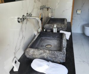 Vasques en pierre naturelle sur meuble noir avec robinetterie murale – Salle de bain de standing Broggio Déco